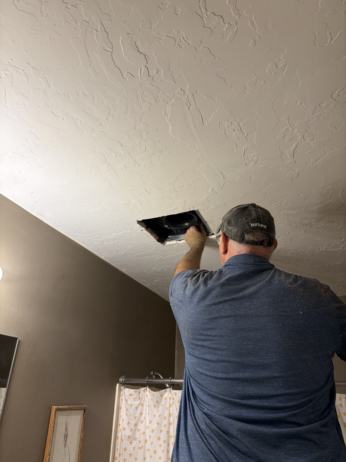 Tracy's husband installing the bathroom exhaust fan