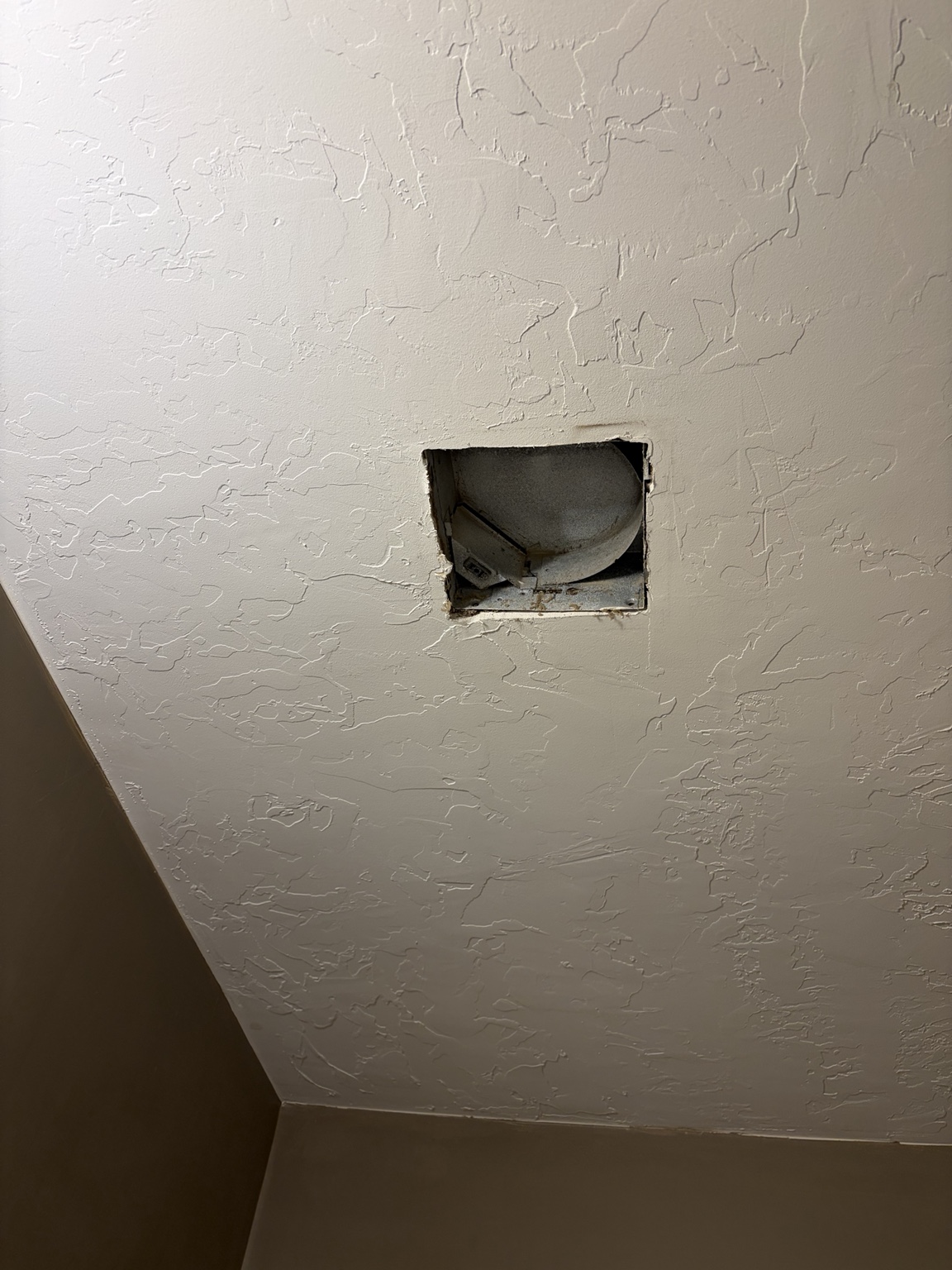 Existing bathroom fan opening exposed in the ceiling